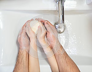 Prevention. dad with daughter washing hands.