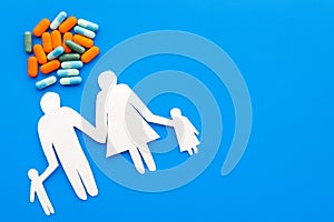 Prevention of diseases. Medicine for family health. Color pills near silhouette of family on blue background top view