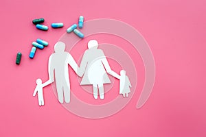 Prevention of diseases. Medicine for family health. Color pills near silhouette of family on pink background top view