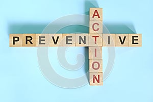 Preventive action business concept. Wooden blocks crossword puzzle flat lay.