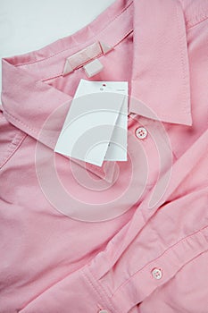 Price tag hang over pink shirt close up view - Image