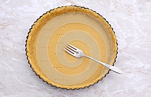Pricking shortcrust pastry case with a metal fork photo