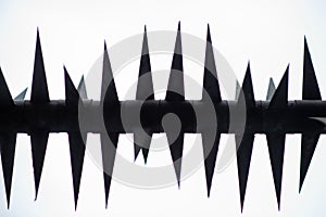 Prickly depression concept. A fence with sharp long metal spikes on a white background. Heaviness, negative