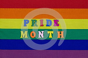 Pride Month letters on the LGBT flag background. Rainbow flag is a symbol of the rights