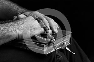 Priest with a bible on his knees