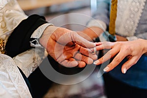 The priest changes the wedding rings on the fingers of the bride and groom. Wedding tradition and ritual. hands of young couples