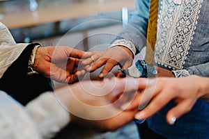 The priest changes the wedding rings on the fingers of the bride and groom. Wedding tradition and ritual. hands of young couples