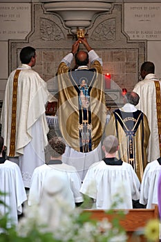 Priest consecrating wine at mass photo