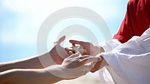 Priest hands giving wooden cross to man, sharing religious faith and hope