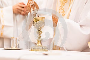 Priest` hands during a wedding ceremony/nuptial mass shallow DOF; color toned image