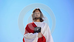 Priest holding bible against sky, servicing to god, teaching christian tradition