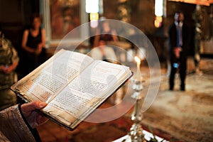 Priest holding bible in church