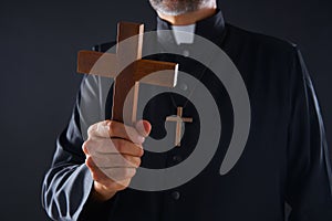 Priest holding cross of wood praying
