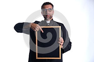 Priest holding empty blackboard copy space
