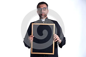 Priest holding empty blackboard copy space