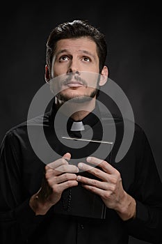 Priest with the Holy Bible. Portrait of priest holding the Holy