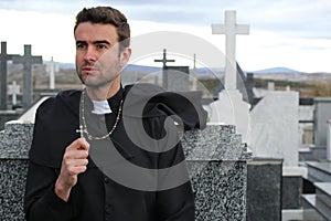 Priest performing an exorcism in a windy cemetery