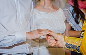Priest placing wedding ring to groom