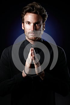 Priest praying with rosary