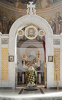 A priest prays for peace in front of the altar in Orthodox church