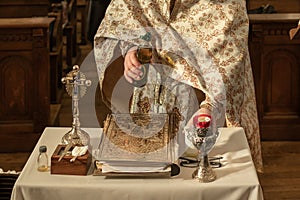 A priest prepares oil for a child& x27;s baptism