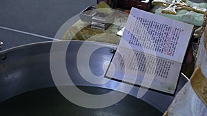 The priest reads the prayer near the baptism basin