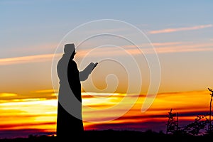 Priest silhoute reading in the sunset light, Romania