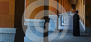 A priest standing in a corridor of a monastery