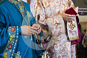 Priests' hands praying during the Sunday mass