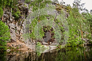 Primal rock on the shore of a calm lake