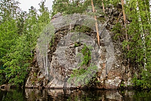 Primal stony shore of a calm lake in Karelia