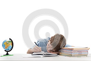 Primare schoolboy with glasses is tired while doing homework. Boy sleeps at his desk Portrait of tired boy on white background