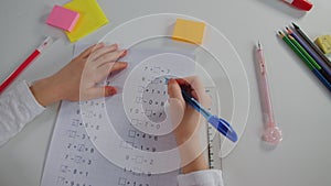 Primary school girl doing mathematics homework lesson, close up, written