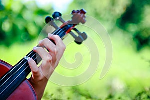 Primary school girl Playing the violin in the garden.