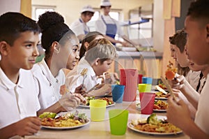 Primary school kids eat lunch in school cafeteria, close up photo