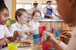 Primary school kids at a table in school cafeteria, close up