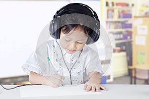 Primary school student studying in class with headset