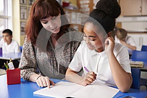 Primary school teacher with a schoolgirl in class, close up