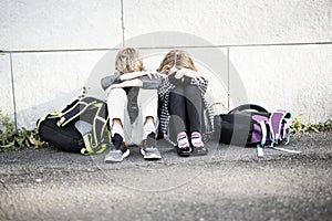 Primary students outside at school standing sad