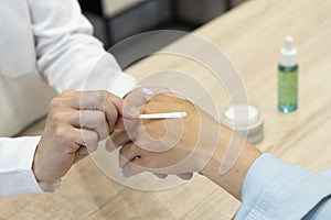 Una mujer probando una crema para la piel en una farmacia photo