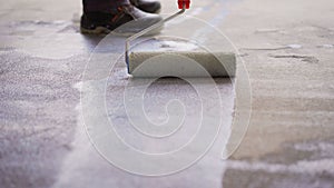 Priming Concrete floor before laying tiles on it, the final preparatory stage for strengthening the surface. Floor