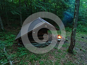 Primitive Bushcraft Adirondack lean to Shelter with campfire in the Wilderness.