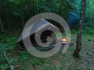 Primitive Bushcraft Adirondack lean to Shelter with campfire in the Wilderness. photo