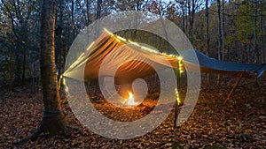 Primitive Tarp Shelter with campfire and fairy lights. Survival Bushcraft setup in the Blue Ridge Mountains near Asheville. During photo