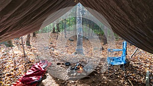 Primitive Tarp Shelter with campfire and fairy lights. Survival Bushcraft setup in the Blue Ridge Mountains near Asheville. During