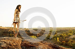 Primitive woman holding a bow. Amazon woman