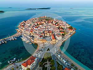 Primosten, Croatia - Aerial view of the old town of Primosten peninsula, St. George\'s Church on a sunny summer morning photo