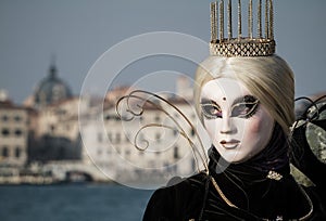 Princess with crown, blondy hair and venetian mask during venice carnival