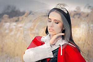 Princess Wearing Tiara and Red Cape Outside