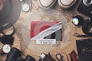 Principality of Sealand Flag Between Traveler`s Accessories on Old Vintage Map. Overhead Shot